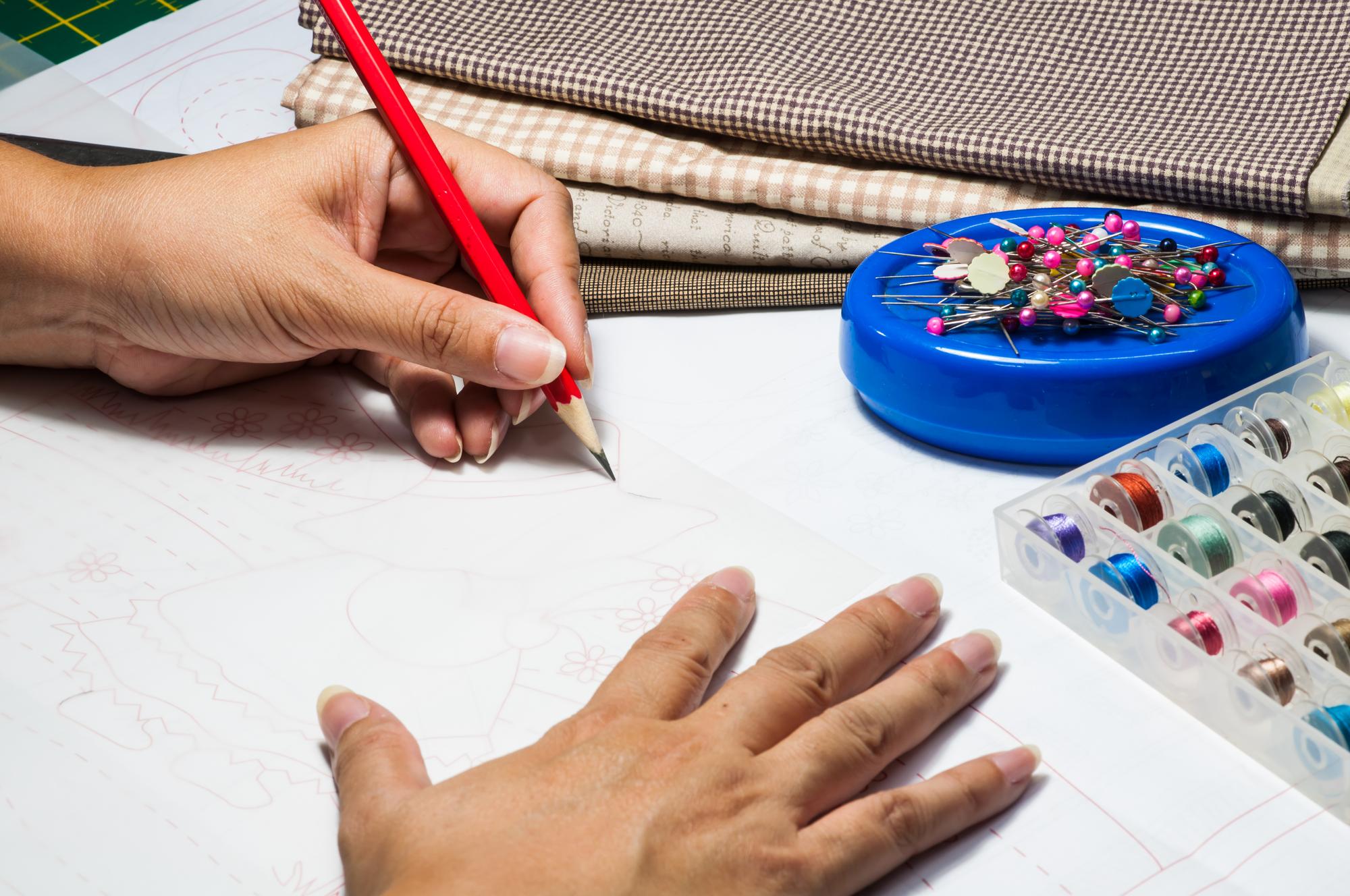 Designer sketch with embroidery sample pinned